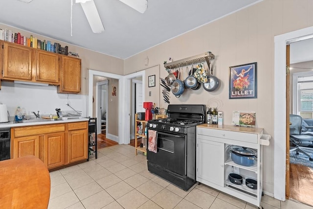 kitchen featuring a sink, light countertops, black range with gas cooktop, and light tile patterned floors