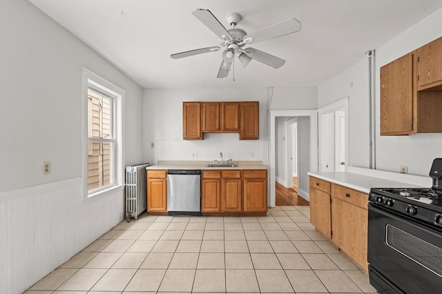 kitchen featuring stainless steel dishwasher, radiator, black gas stove, ceiling fan, and a sink