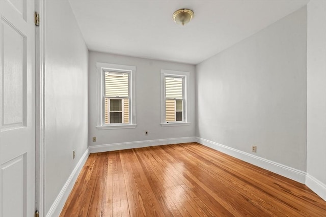 spare room featuring light wood-style floors and baseboards