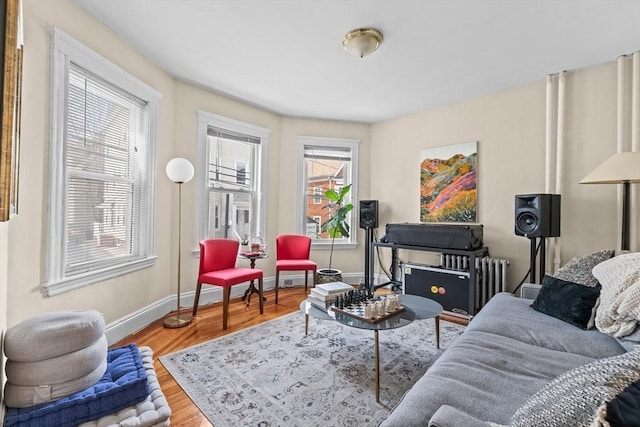 living area with baseboards, radiator heating unit, and wood finished floors