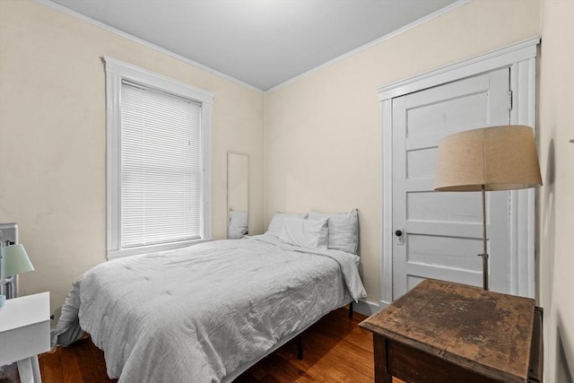 bedroom featuring ornamental molding and wood finished floors