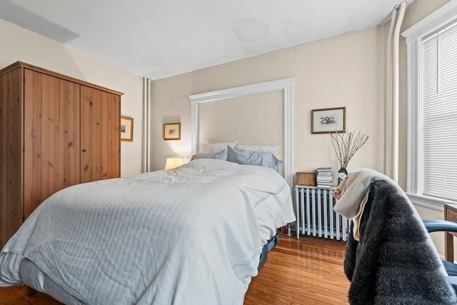 bedroom featuring radiator heating unit and wood finished floors