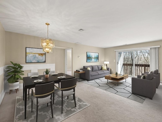 dining room featuring a chandelier, visible vents, and carpet flooring