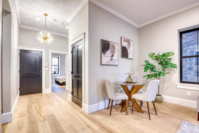 dining area featuring an inviting chandelier, crown molding, and light hardwood / wood-style flooring