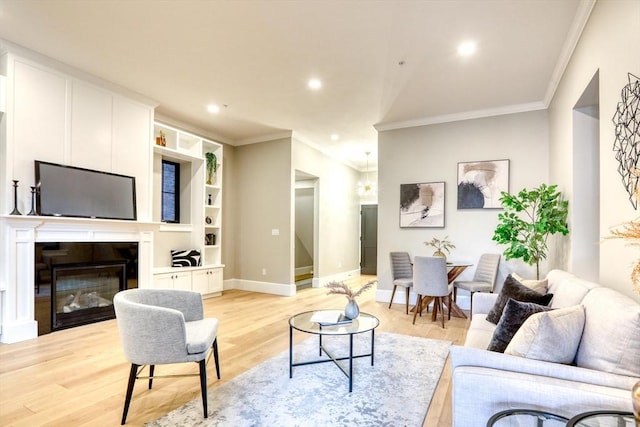 living room with crown molding, built in features, and light hardwood / wood-style flooring