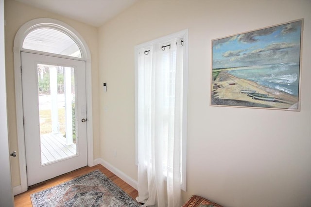 doorway featuring light wood-type flooring and baseboards