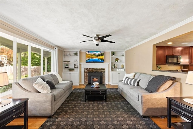 5-R Valeda, Rehoboth, MA 02769 - living area featuring a ceiling fan, ornamental molding, a brick fireplace, a textured ceiling, and built in shelves