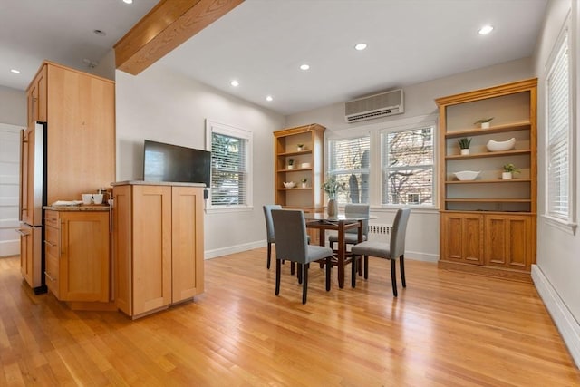 dining room with beamed ceiling, a wall mounted AC, baseboard heating, and light hardwood / wood-style flooring