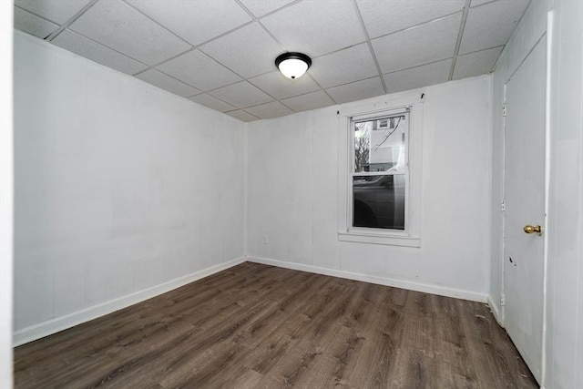 unfurnished room featuring dark hardwood / wood-style flooring and a drop ceiling