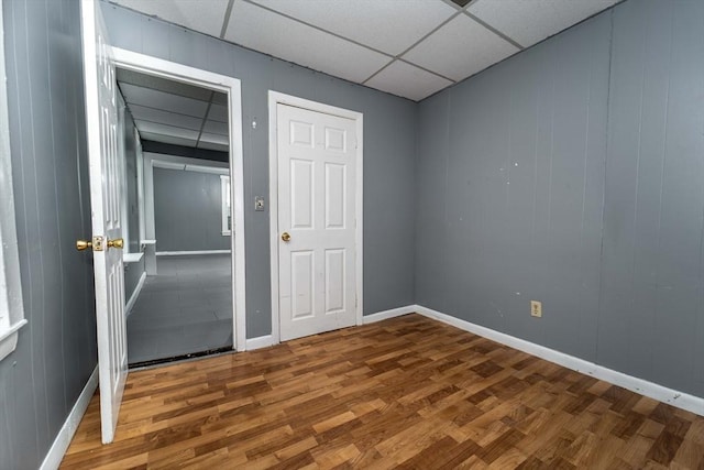 unfurnished room featuring a drop ceiling and hardwood / wood-style flooring