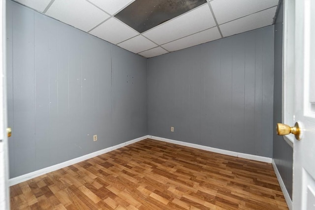 spare room featuring hardwood / wood-style flooring and a drop ceiling