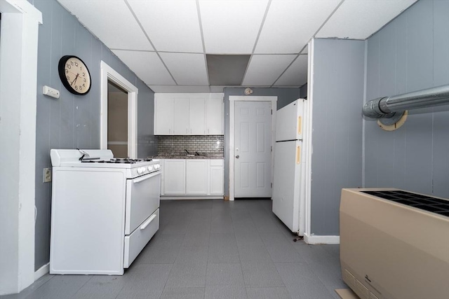 kitchen with backsplash, a drop ceiling, white appliances, sink, and white cabinets