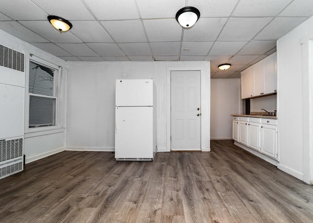 interior space with white cabinets, hardwood / wood-style floors, and white fridge