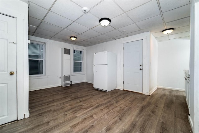 spare room featuring dark hardwood / wood-style floors and a drop ceiling