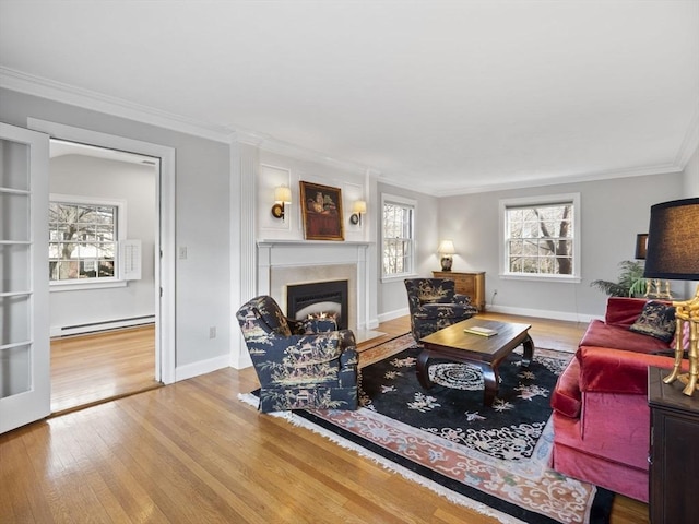 living room with baseboards, a fireplace with flush hearth, hardwood / wood-style flooring, a baseboard heating unit, and crown molding