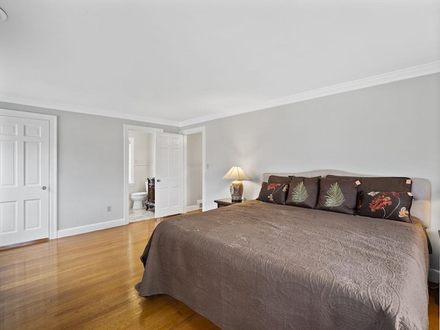 bedroom with baseboards, wood finished floors, and crown molding