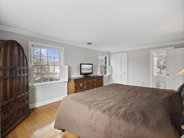 bedroom with visible vents, light wood-style flooring, ensuite bath, crown molding, and baseboards