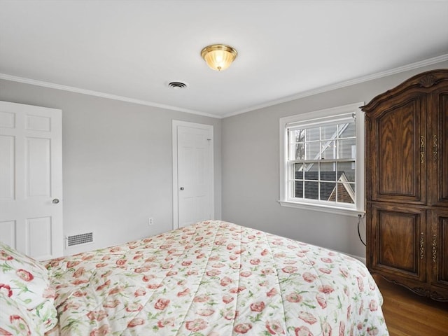 bedroom featuring visible vents, wood finished floors, and ornamental molding