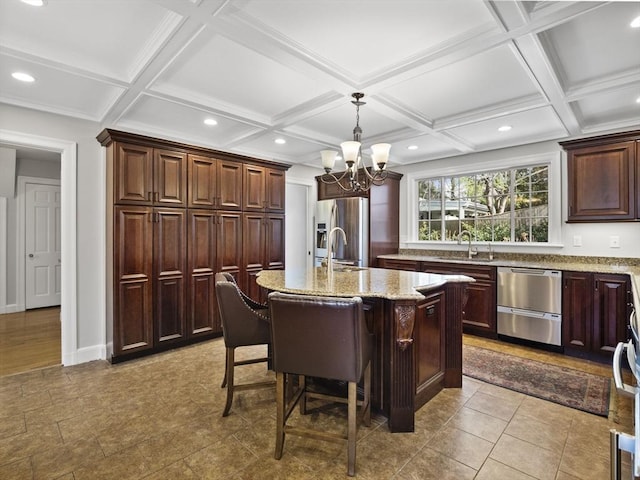 kitchen featuring stainless steel fridge with ice dispenser, a kitchen island with sink, light stone countertops, and a sink