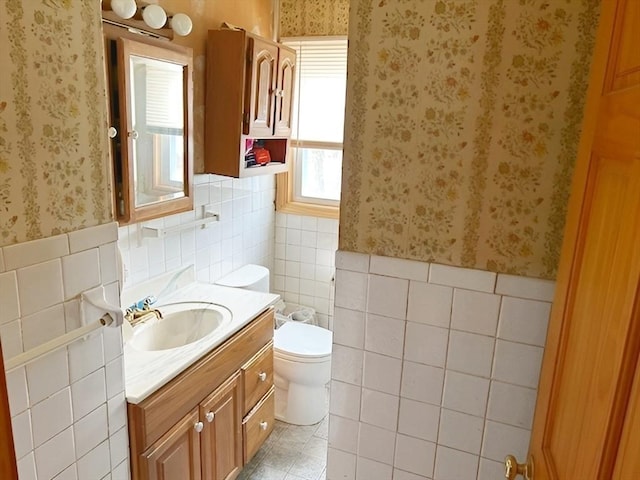 bathroom with vanity, toilet, and tile walls