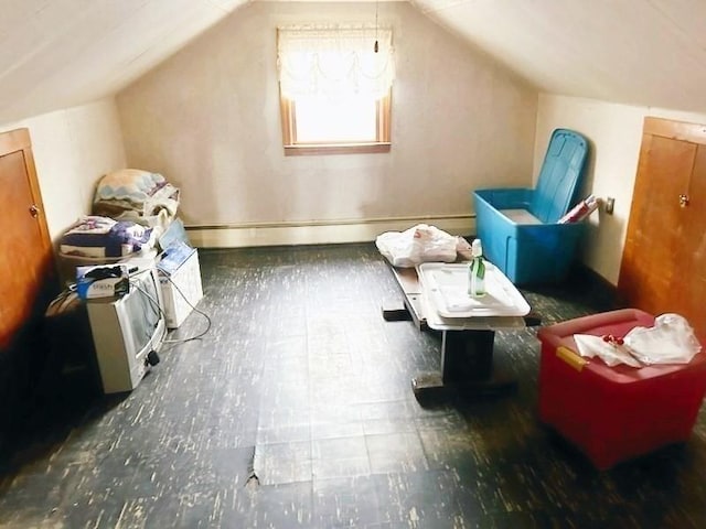 additional living space featuring vaulted ceiling and a baseboard heating unit