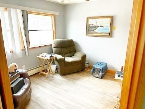 sitting room featuring a baseboard radiator and light hardwood / wood-style floors