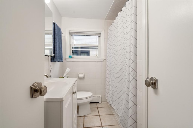 bathroom with tile patterned flooring, tile walls, a baseboard heating unit, toilet, and vanity