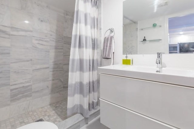 bathroom featuring toilet, vanity, and curtained shower