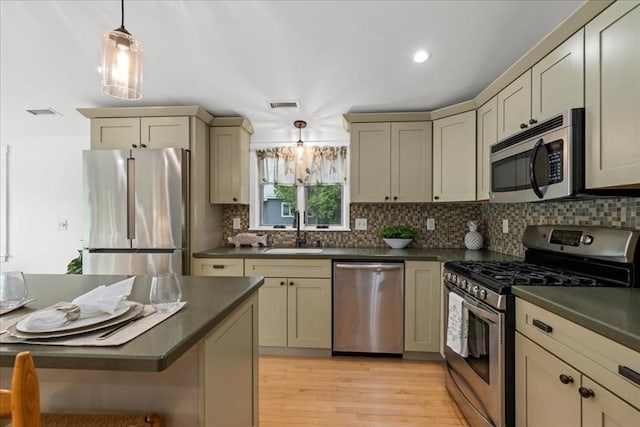 166 Klondike Rd, Dudley, MA 01571 - kitchen featuring stainless steel appliances, a sink, dark countertops, light wood-style floors, and tasteful backsplash