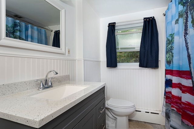 bathroom with curtained shower, vanity, toilet, and a baseboard heating unit