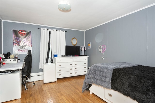 bedroom featuring light wood-type flooring, baseboard heating, and crown molding