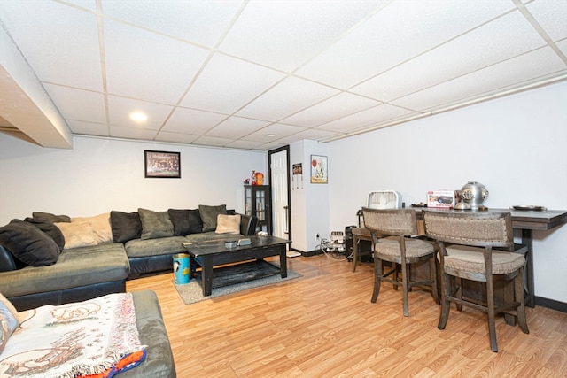 living room with hardwood / wood-style flooring and a paneled ceiling