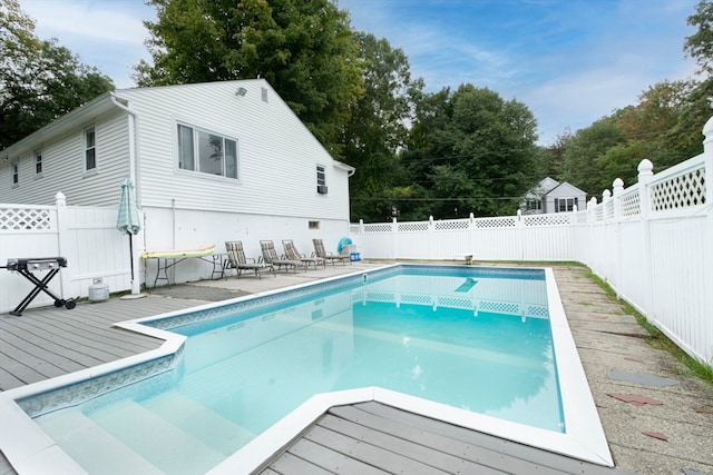 view of pool with a deck and a diving board