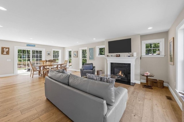 15 Littlefield Pond Rd, Harwich, MA 02645 - living room featuring a glass covered fireplace, light wood-type flooring, plenty of natural light, and recessed lighting