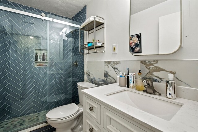 bathroom with decorative backsplash, vanity, a shower with door, and toilet