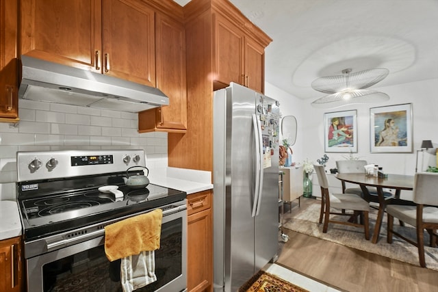 kitchen featuring hardwood / wood-style flooring, stainless steel appliances, and decorative backsplash