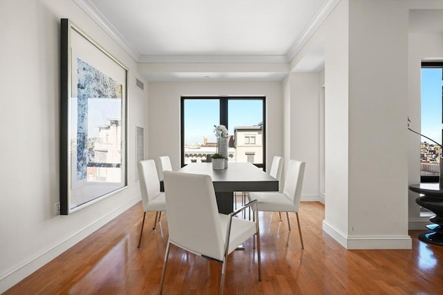 dining room featuring ornamental molding, wood finished floors, and baseboards