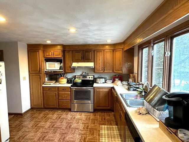 kitchen with sink, white appliances, and a healthy amount of sunlight