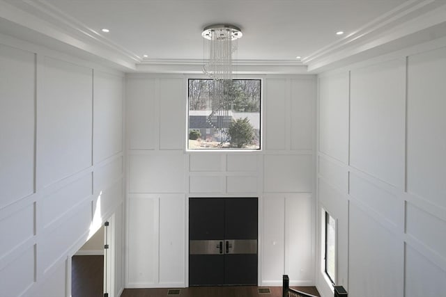 interior details featuring a raised ceiling and a chandelier