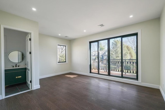 interior space with access to exterior, dark hardwood / wood-style flooring, sink, and ensuite bath