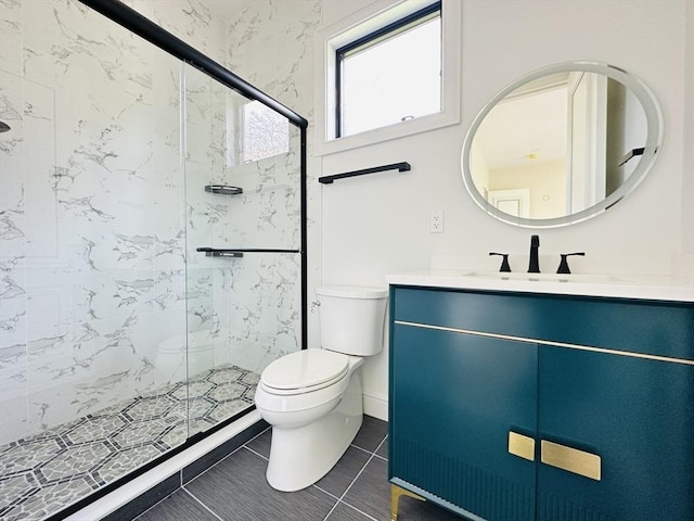 bathroom with tile patterned floors, vanity, toilet, and a shower with door