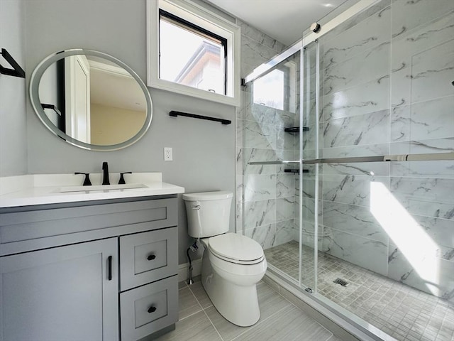 bathroom featuring tile patterned flooring, vanity, toilet, and a shower with door