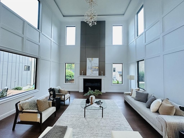 living room featuring a healthy amount of sunlight, a high ceiling, and an inviting chandelier