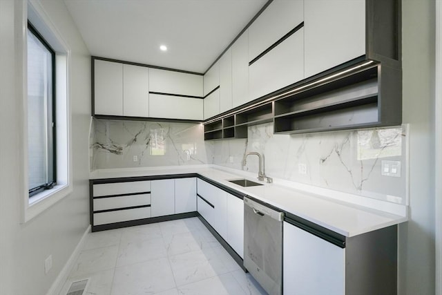 kitchen featuring dishwasher, white cabinetry, sink, and tasteful backsplash