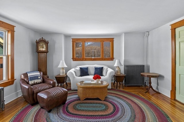 sitting room featuring hardwood / wood-style flooring, a healthy amount of sunlight, and radiator heating unit