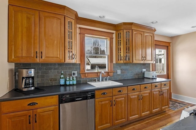 kitchen featuring tasteful backsplash, dishwasher, sink, and hardwood / wood-style floors