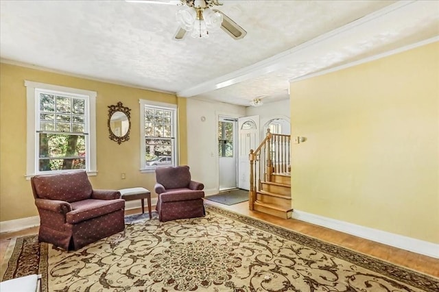 living area with ceiling fan and a textured ceiling