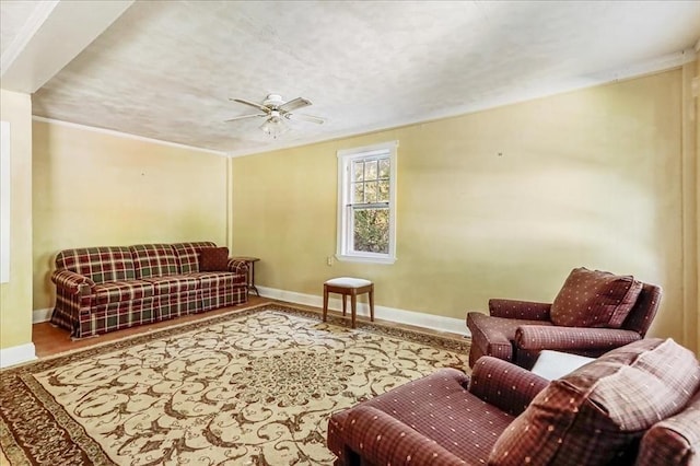 living room with ceiling fan, wood-type flooring, and ornamental molding