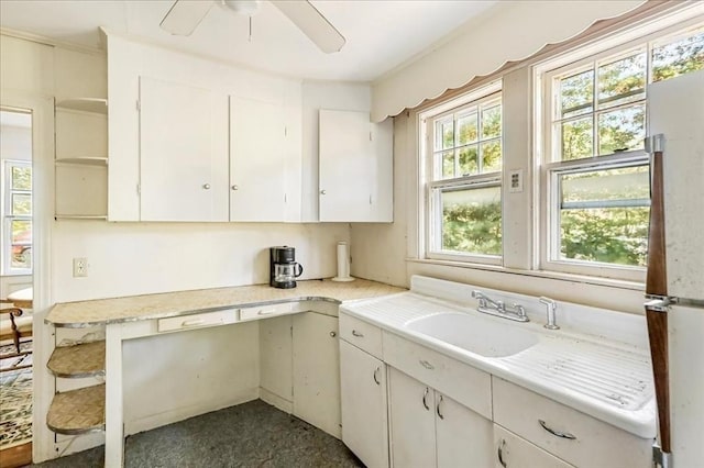 kitchen with ceiling fan, white cabinets, and sink