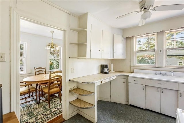 kitchen featuring white cabinetry, sink, hanging light fixtures, and ceiling fan